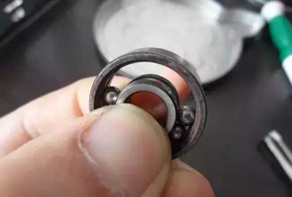 用手將軸承拿起，需要注意要向有滾珠的方向頂住
